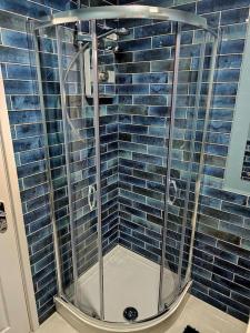 谢菲尔德Homebird Property - Waltz House的浴室铺有蓝色瓷砖,设有淋浴。