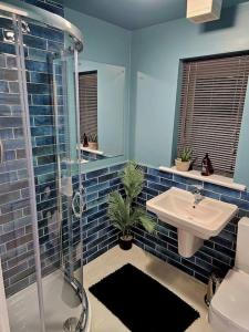 谢菲尔德Homebird Property - Waltz House的蓝色的浴室设有水槽和淋浴
