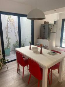 圣多美Acogedora casa en Santo Tome的厨房配有白色的桌子和红色的椅子