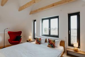普鲁滕SandDorn 1 und 2的一间卧室配有一张床和一张红色椅子