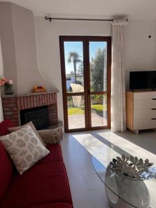 下麦克加诺Terrassen Wohnung Bacio del Sole的客厅配有红色的沙发和玻璃桌