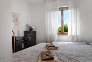 下麦克加诺Terrassen Wohnung Bacio del Sole的一间卧室配有一张床,上面有两条毛巾