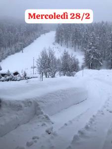 博格塔塞斯特雷Sestriere Borgata appartamento in montagna Casa di Bertu的雪覆盖的路上堆积的雪