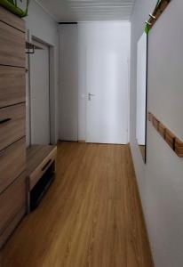 陶普利茨Grimming view Apartment的一间空房间,铺有木地板,拥有白色的墙壁