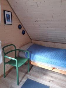 KarsinQubalonka Saunarium bis Bory Tucholskie的一张位于带绿椅的房间的床位