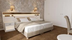 布拉格Hotel Savoy Prague的卧室配有一张白色大床和一把椅子