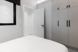塞萨洛尼基#Nereids Apts by halu! Apartments的白色卧室设有白色橱柜和窗户