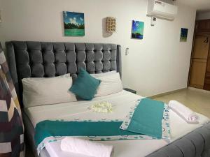 杉祖Lux Suites Lamera Beachfront Apartments的一间卧室配有一张大床和灰色床头板