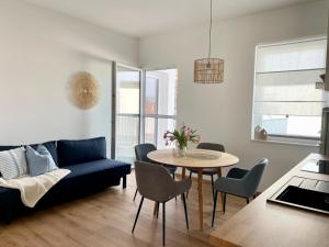 滨湖默尔比施Pannonia Apartments的客厅配有蓝色的沙发和桌子