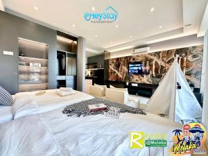 马六甲Bali Residence Melaka By Heystay Management的卧室配有一张白色大床和电视。