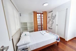 利马Hostel Prada的一间小卧室,配有一张床和一扇门