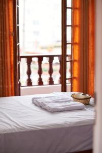 利马Hostel Prada的一张带两条毛巾和一篮子的床
