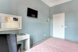 罗马罗马克劳迪娅楼特米尼酒店的客房设有书桌和墙上的电视