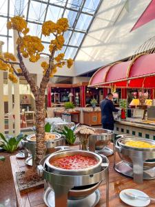 戈亚尼亚卡斯特罗公园酒店的桌子中间有树的餐厅