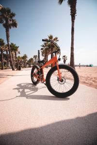 格里莫莱斯德拉梅尔酒店的一辆橘子自行车停在海滩附近的人行道上