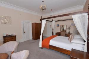 SteetonSteeton Hall Hotel & Restaurant的一间卧室配有一张大床和一把椅子