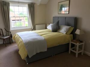 约克Close House Cottage的一间卧室配有一张带黄色毯子和窗户的床