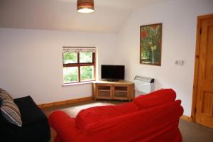 StraidBallylagan Organic Farm的客厅配有红色沙发和电视