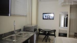恩德培CommonLens Inn的一个带水槽的厨房和墙上的电视