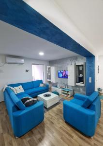 索科矿泉村Grand Blue 2 Bedroom Apartment Sokobanja的客厅配有蓝色的沙发和电视