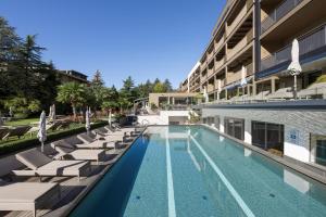 纳图尔诺Feldhof DolceVita Resort的一座带躺椅的游泳池和一座建筑