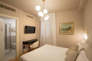 威尼斯Daplace - Antica Casa Coppo的一间卧室配有一张床、一张书桌和一台电视