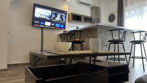博尔戈Appartement Maenat的客厅配有桌子和墙上的电视