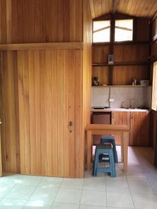 德雷克Cabañas Bajo Bosque Drake的厨房设有木墙、桌子和2把凳子。