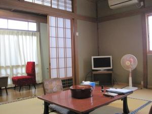尾道市住之江区旅馆 的客厅配有桌子和电视