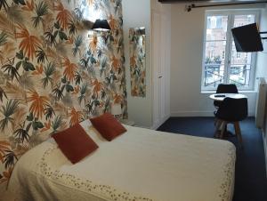 翁弗勒尔叠水瀑布 – 迷人酒店的一间卧室配有一张带花卉壁纸的床