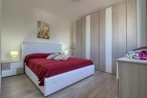 卡斯特里尼亚诺德尔卡波Enjoy Leuca Mare的卧室配有一张带红色毯子的白色床