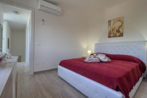 卡斯特里尼亚诺德尔卡波Enjoy Leuca Mare的白色卧室配有一张带红色毯子的床
