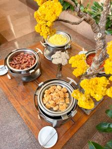 戈亚尼亚卡斯特罗公园酒店的一张桌子,上面放着几盘食物和鲜花