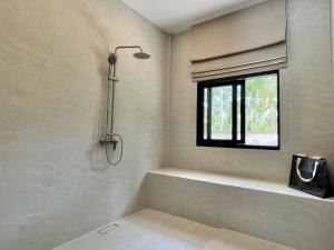 苏梅岛Moorea Boutique Resort Samui的带浴缸的浴室和窗户。