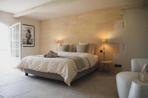 阿尔勒Mas d images styled by Scapa Home的一间卧室配有一张大床和一把椅子