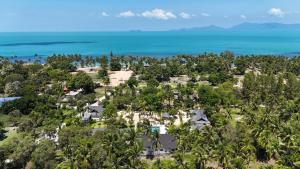苏梅岛Moorea Boutique Resort Samui的大海旁山丘上房屋的空中景观
