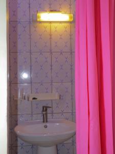 NianingLa Case a Mamy的一间带水槽和粉红色淋浴帘的浴室
