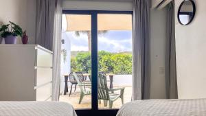 Blue BayBlue Bay Resort luxury apartment Palm View的一间卧室设有一扇门,可通往带桌子的庭院。