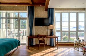 青岛青岛美墅假期酒店12号海边别墅的一间卧室配有书桌、一张床和窗户。