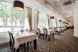 波切尼斯Hotel pod Zámkom的餐厅设有白色的桌椅和窗户。