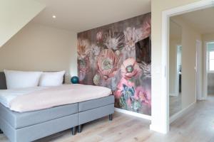 韦斯特兰Family Hüs的一间卧室配有一张带花卉墙壁的床