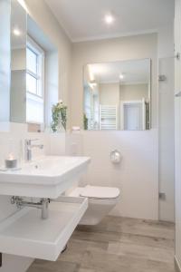 韦斯特兰Hedigen Hüs的白色的浴室设有水槽和卫生间。