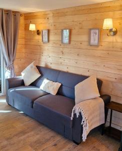 BillyCozies Cabin的一张蓝色的沙发,位于一个木墙房间内