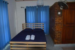 安帕赖Mereiyans Village Villa的一间卧室配有蓝色的床和两条白色毛巾
