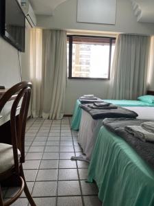 维拉维尔哈Apartamento em frente a praia Costa 1001的客房设有两张床和窗户。