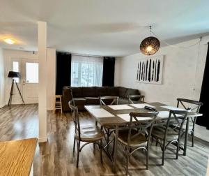 瓦勒多Auberge Chez Moi Chez Toi的用餐室以及带桌椅的起居室。