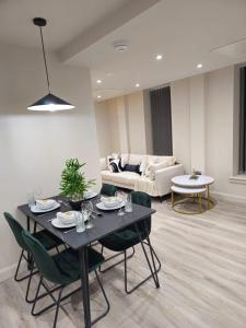 利兹Luxury Serviced Penthouse - City Centre - En Suite Bedrooms - Free Netflix的客厅配有桌椅和沙发