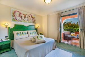 奥罗塞伊Villaggio Cala Ginepro Resort & SPA的一间卧室配有一张床,享有庭院的景色