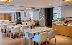马德拉潘帕斯Rincón del Duende Resort y Spa de Mar的餐厅设有白色的桌椅和柜台