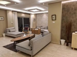 安曼Amman's most prestigious的客厅配有沙发和桌子。